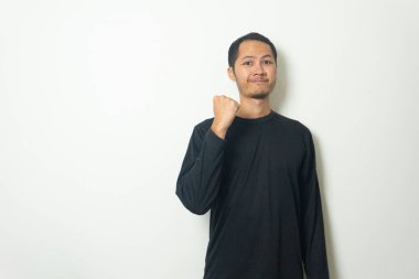 Siyah tişört giyen genç Asyalı adamlar yumruklarını sıkarak beyaz arka planı izole ettiler.