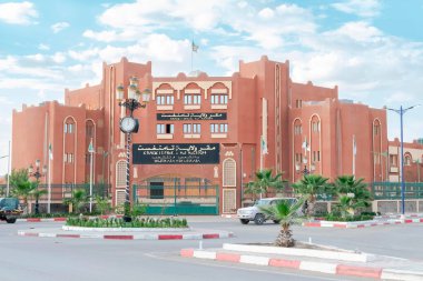 Tamanrasset, Cezayir - 18 Mart 2025: Genel merkez binasında Cezayir bayrakları sallanıyor, Arapça ve Tamazight tabelasında 