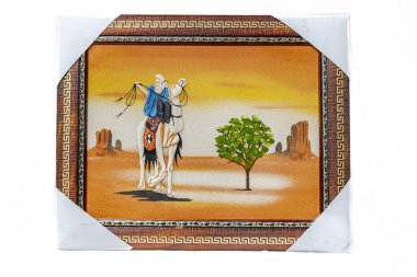 Geleneksel giysiler ve baş örtüsü takan bir Tuareg erkeğinin kumlu bir resmi Sahra Çölü 'nde yürüyen beyaz dromedary deve sürüyor. Beyaz kağıtla korunan altın desenli ve köşeli çerçeveler.