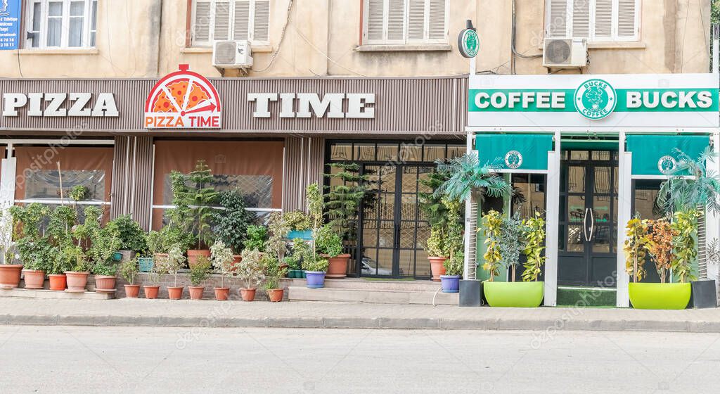 Algiers, Algeria - November 8, 2024: Pizza Time and a coffee shop facade on the main street of Val D'Hydra features a logo named 