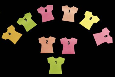 9 tane yapışkan not defteri 1 'den 9' a kadar numaralandırılmış ve bir yay şeklinde dizilmiş. Somon, turuncu, sarı, yeşil ve pembe renkler. Karşıt bir siyah arkaplanda izole edilmiş.