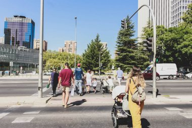 Avrupa 'da karşıdan karşıya geçen insanlar, zebra çizgili yaya geçitleri. İki çocuklu bir kadın okula gidiyor..