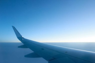 Yükselmek İçin Bir Görüntü: Düzlem Penceresinden Sahneler Açılıyor. Bulutların üzerinde bir uçağın kanadı.