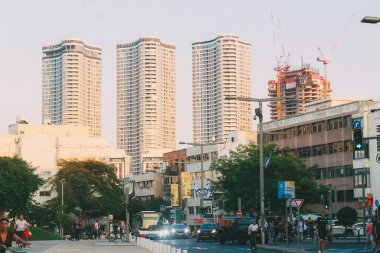 Gün batımında Tel Aviv, İsrail 'deki binalarla caddeleri geçen arabalar..