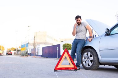 good looking man making a call to car insurance after engine breakdown