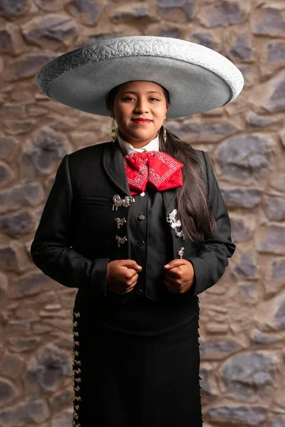 female mexican mariachi woman smiling using a traditional mariachi girl suit on a pure white background. good looking latin hispanic musician feminine mariachi wearing a mexican white hat