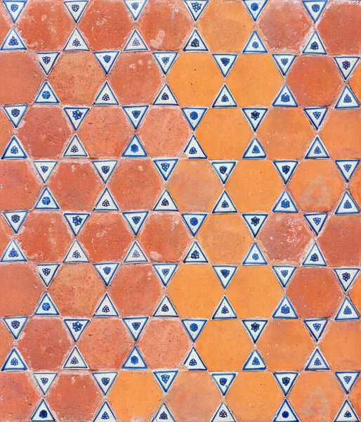 orange mexican wall with talavera ceramic triangular tiles, pattern of triangles and hexagons