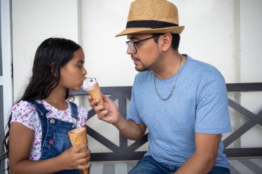 İspanyol baba, kızına dondurma veriyor. Birlikte dışarıda iyi vakit geçiriyor.