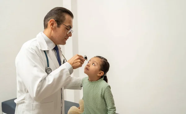 İspanyol doktor fenerli kız öğrenciyi kontrol ediyor.