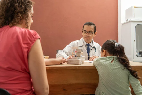 Doktor hasta bir kıza bir sürü ilaç veriyor. Küçük kız endişeli çünkü çocuk doktoru çok fazla ilaç yazıyor.