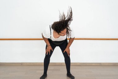 Erkek balerin kafa tokuşturuyor, uzun saçlı adam kafa sallıyor ve rock müzik dinliyor.