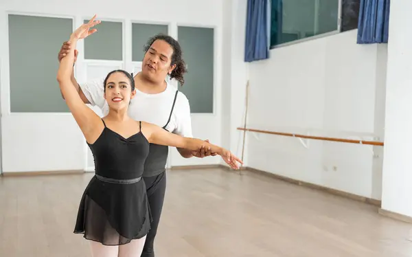 african american male ballet dancer instructor teaching and training a young student hispanic ballerina, learning new skills