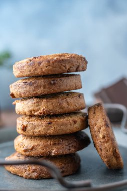 Mavi peçeteli çikolata parçalı Amerikan kurabiyeleri ve demir saplı alüminyum bir tabak..