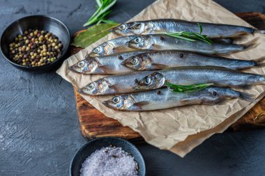 Tahtada taze kapelinli balık ve baharatlı siyah masa..