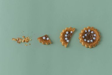 Bir bütün ve bir bisküvi parçalara ayrıldı. Renkli arka planda yoğunlaştırılmış sütlü bisküvi kurabiyeleri. Düz Yat.