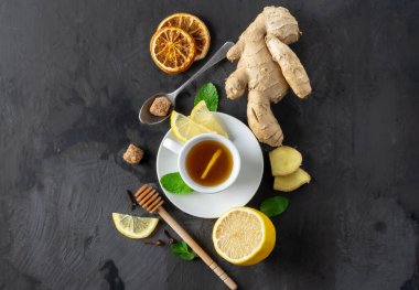 Soğuk algınlığı için gerekli malzemeler. Koyu arkaplanda zencefil çayı.