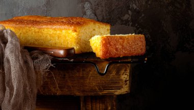 Eski ahşap bir bankta metal bir rafta vanilyalı kek. Kır manzarası ev yapımı ikramların sadeliği ve sıcaklığını vurguluyor. Rahat ve nostaljik bir atmosfer için mükemmel..