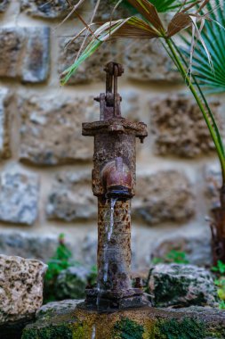Yafa 'nın tarihi sokaklarında paslı bir su pompası, yıpranmış metal yapısıyla kentin kültürel mirasını ve zamansız karakterini sembolize ediyor, geçmişin cazibesini koruyor..