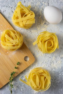 Çiğ yumurta ve taze kekik ile pişirilmemiş fettucine yuvaları. Genel yemek hazırlama sahnesi.