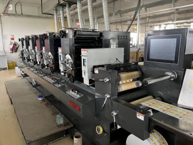 Dhaka, Bangladeş - 3 Mart 2023. Modern baskı makinesi ve diğer makinelerle baskı fabrikası içi. Beş renkli basım litografi makinesi çalışıyor.