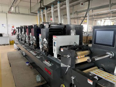 Dhaka, Bangladeş - 3 Mart 2023. Modern baskı makinesi ve diğer makinelerle baskı fabrikası içi. Beş renkli basım litografi makinesi çalışıyor.