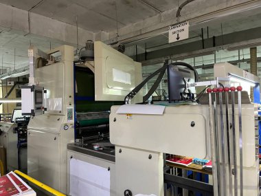 Dhaka, Bangladeş - 3 Mart 2023. Modern baskı makinesi ve diğer makinelerle baskı fabrikası içi. Beş renkli basım litografi makinesi çalışıyor.