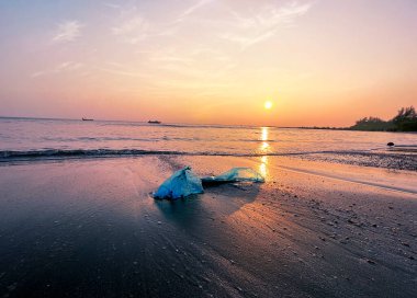 Deniz sahilinde çöp döküldü. Kullanılmış kirli plastik ürünler. Çevresel plastik kirliliği. Ekolojik sorun.