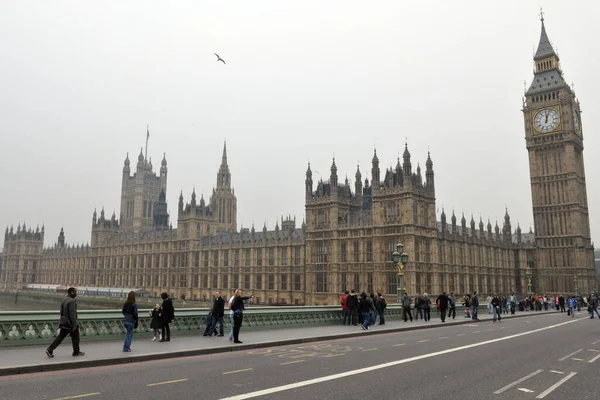 2011年3月26日 在英国伦敦 人们在雾天穿过威斯敏斯特桥 威斯敏斯特是英国政治的中心 也是国会大厦标志性的大本钟塔的所在地 — 图库照片