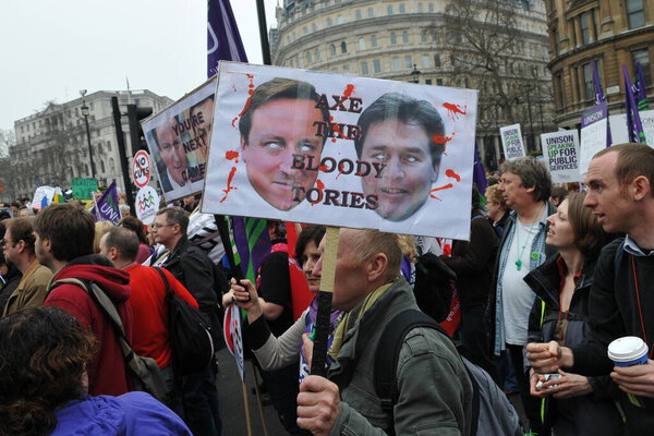 LONDON - MARCH 26: A group of protesters march through the streets of the British capital during a large TUC organized anti-cuts rally on March 26, 2011 in London, UK.