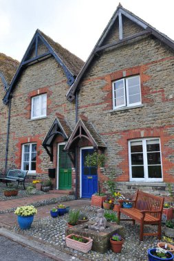 İngiliz köyünde bir caddede güzel, eski teraslı evler ve bahçeler. 
