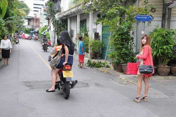 stock image A motorbike taxi transports a passenger on a city street on August 10, 2011 in Bangkok, Thailand. Motorbike taxis are a popular choice for the Thai capital's heavily congested roads. 