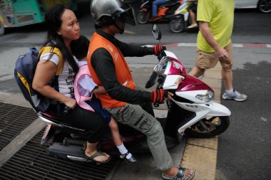 Bir motosiklet taksisi 10 Ağustos 2011 'de Bangkok, Tayland' da bir yolcu taşır. Motosiklet taksileri Tayland başkentinin yoğun yolları için popüler bir seçimdir.. 