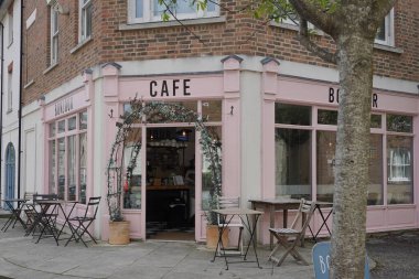 3 Mayıs 2023 'te İngiltere' nin Poundbury kentinde şehir merkezi yakınlarındaki bir sokakta bir kafe görülmektedir. Dorset kasabası bağımsız kafeler, restoranlar ve dükkanlarla gelişen yerel ekonomisi ile ünlüdür..