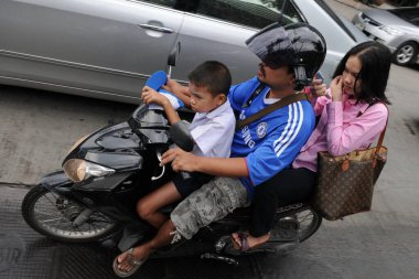 Motosikletçiler ve yolcular 16 Ağustos 2011 'de Bangkok, Tayland' da şehir merkezinde bir caddeye binerler. Tayland başkentinin yoğun yollarında genellikle motosikletler tercih edilir..