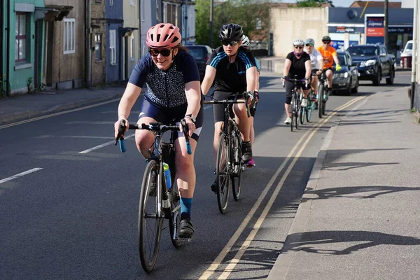 2023年5月20日に英国ウェストベリーの町の中心部の道路に沿って女性サイクリストのグループが乗っています — ストック写真