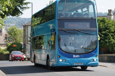 Bir çift katlı otobüs 8 Haziran 2023 'te Bath, İngiltere' de şehir merkezi caddesi boyunca ilerler. Somerset şehri her yıl 4 milyon ziyaretçiyle popüler bir seyahat merkezidir..