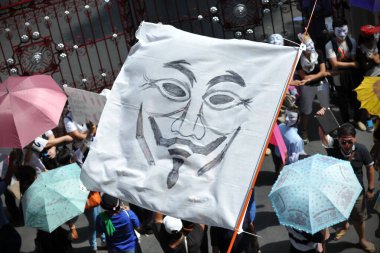 30 Haziran 2013 'te Bangkok, Tayland' da şehir merkezi alışveriş bölgesinde maskeli protestocular gösteri yapıyor. Protestocular hükümetin ordu tarafından devrilmesi için çağrıda bulunuyorlar..