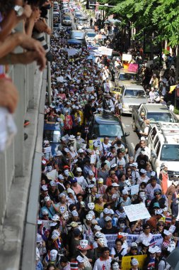 30 Haziran 2013 'te Bangkok, Tayland' da şehir merkezi alışveriş bölgesinde maskeli protestocular gösteri yapıyor. Protestocular hükümetin ordu tarafından devrilmesi için çağrıda bulunuyorlar..