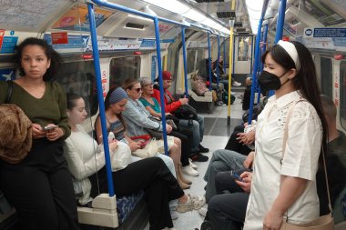 İnsanlar 31 Temmuz 2023 'te Londra, İngiltere' de bir yeraltı trenine biniyorlar. 1863 'te açılan Londra metro ağı dünyanın en eski demiryolu ağı ve bugün yılda 1,5 milyar yolcu taşıyor..