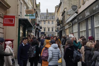 Tarihi Bath Abbey ve çevresindeki binalar 30 Kasım 2019 tarihinde Bath, İngiltere 'de bir şehir merkezi caddesinde görülmektedir. Somerset şehri, yılda 4 milyon ziyaretçi alan popüler bir seyahat merkezidir..