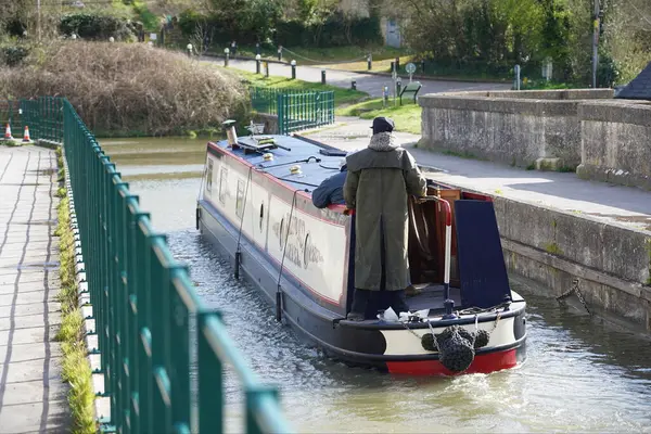 stock image A narrow boat navigates an aqueduct bridge on the Kennet and Avon canal on March 12, 2020 in Avoncliff, UK. 