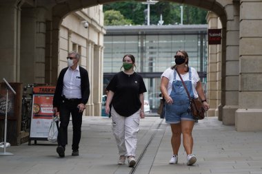 Alışveriş yapanlar, 24 Temmuz 2020 'de İngiltere' nin Bath kentindeki mağazalarda maske kullanımını zorunlu kılan yeni bir yasa olarak yüz maskesi takıyorlar. Yüz maskesi takmak Covid-19 salgınıyla savaşmak içindir..