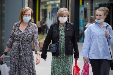 Alışveriş yapanlar, 24 Temmuz 2020 'de İngiltere' nin Bath kentindeki mağazalarda maske kullanımını zorunlu kılan yeni bir yasa olarak yüz maskesi takıyorlar. Yüz maskesi takmak Covid-19 salgınıyla savaşmak içindir..