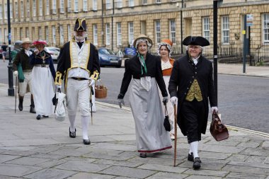 24 Temmuz 2020 'de Bath, İngiltere' de geleneksel kıyafet giyen insanlar şehir caddesi boyunca yürüyorlar. Somerset şehri Jane Austin 'in eviydi ve çoğu zaman drama için bir mekandır..