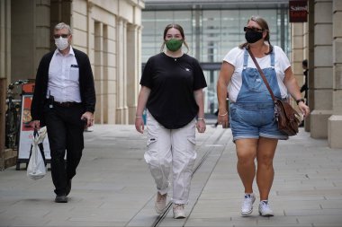 Alışveriş yapanlar, 24 Temmuz 2020 'de İngiltere' nin Bath kentindeki mağazalarda maske kullanımını zorunlu kılan yeni bir yasa olarak yüz maskesi takıyorlar. Yüz maskesi takmak Covid-19 salgınıyla savaşmak içindir..