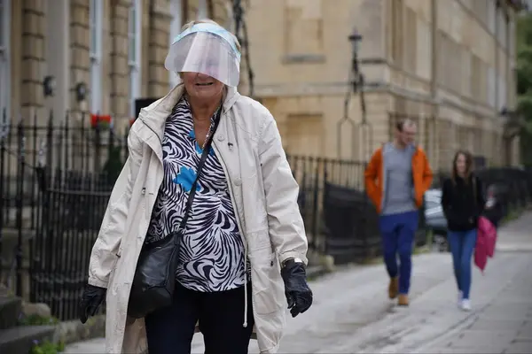 stock image elderly woman wears a face covering on a city centre street on July 24, 2020 in Bath, UK