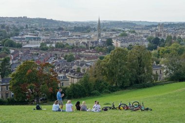 İnsanlar 19 Eylül 2020 'de Bath, İngiltere' de şehrin dışındaki bir çayırda güneşli bir günün tadını çıkarıyorlar..