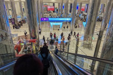 Uçak yolcuları 14 Aralık 2023 'te Dubai Uluslararası Havalimanı' ndaki geçiş denetimi ve göçmenlik için Dubai, BAE 'de yürüyen merdiven kullanırlar..