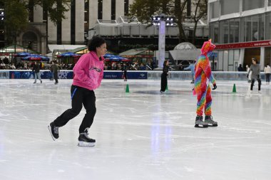 People ice skate at Bryant Park ice rink on October 31, 2023 in New York City, USA. The midtown Manhattan park is a popular travel destination with cafes, shops and during the winter its ice rink. clipart