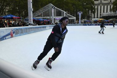 People ice skate at Bryant Park ice rink on October 31, 2023 in New York City, USA. The midtown Manhattan park is a popular travel destination with cafes, shops and during the winter its ice rink. clipart